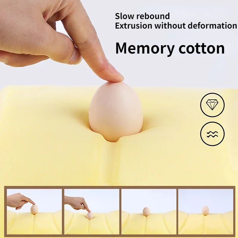 A hand presses a soft, beige memory cotton pillow into a yellow foam surface demonstrating slow rebound extrusion.