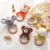 A collection of crochet bunny rattles featuring natural wood teether rings in orange, gray, yellow, and brown.