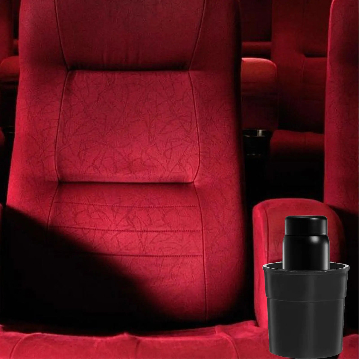 A close-up of a red upholstered chair with a black cup holder attached to the armrest.