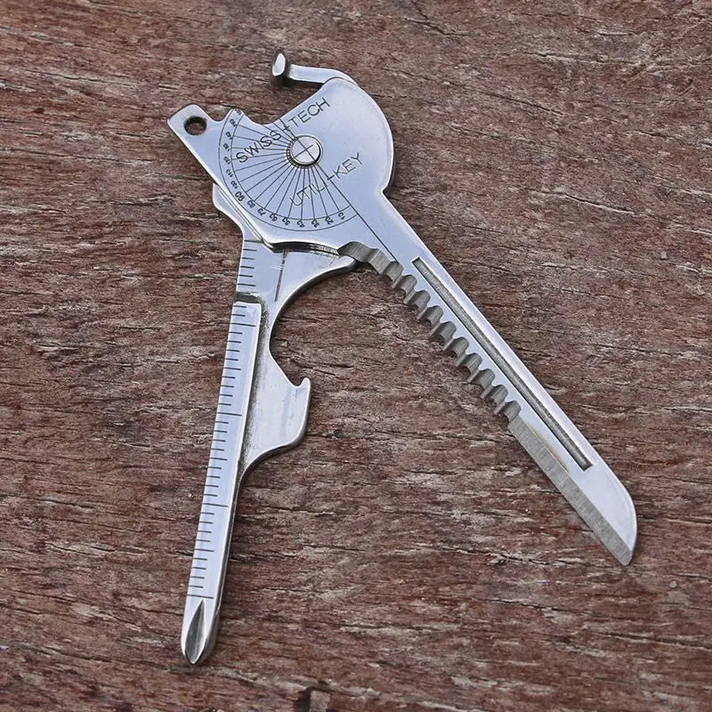 Silver multi-tool keychain with a serrated blade and various tools on a wooden surface.