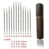 A set of twelve self-threading sewing needles with varying lengths stored in a wooden cylindrical case.