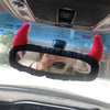 Plush bear and pig rearview mirror covers attached to a car's interior rearview mirror.