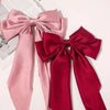 A set of pink and red silk bows used as hair accessories for ponytails.