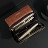 Portefeuille clutch en cuir marron avec fermeture éclair, montrant un smartphone et des cartes à l'intérieur.