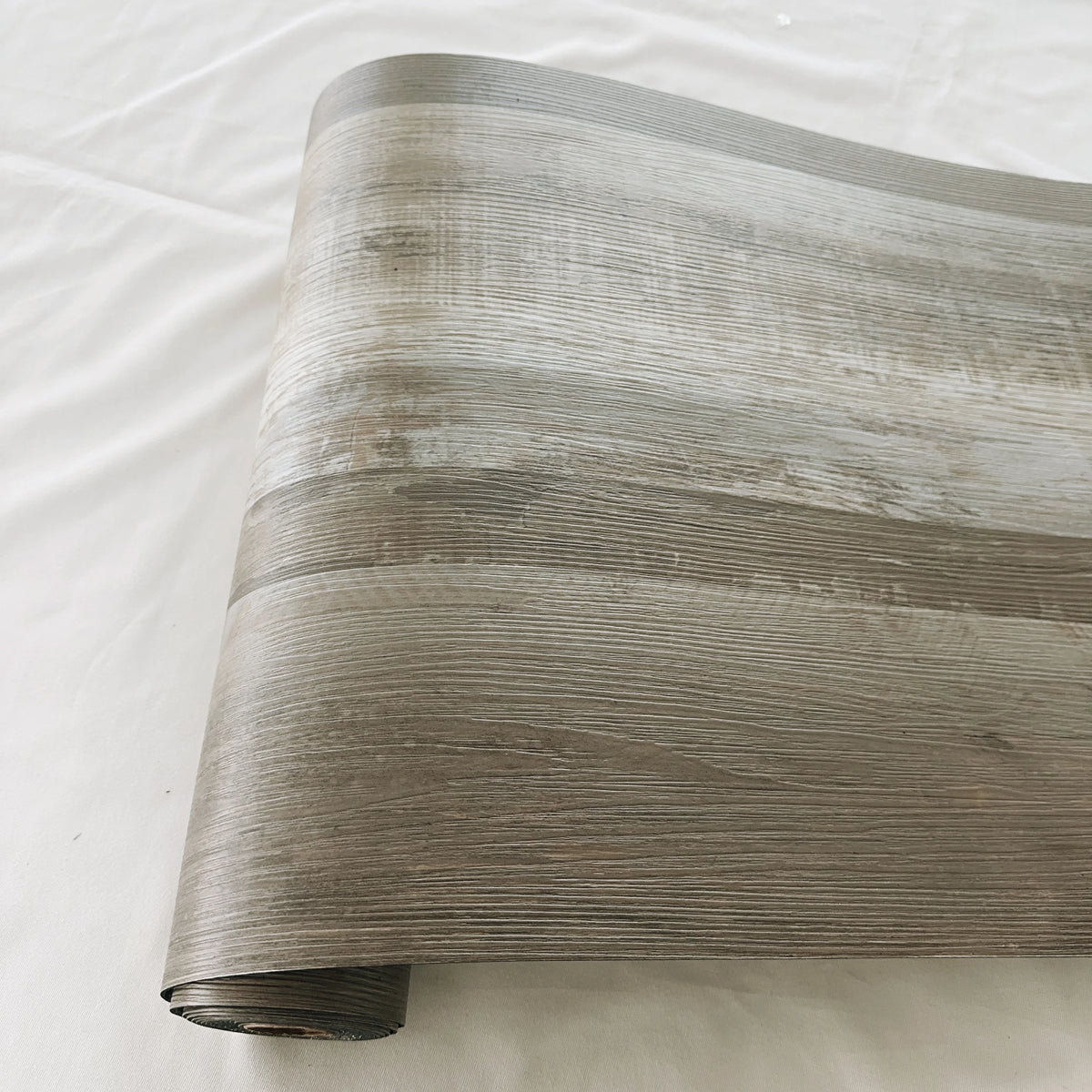 Roll of wood grain PVC self-adhesive decal showing horizontal lines in a gray tone.