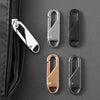 A collection of metal zipper pulls in silver, black, and rose gold are displayed against a dark gray background.