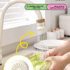A hand is using a kitchen faucet sprayer with a filter to spray water onto vegetables in a bowl.