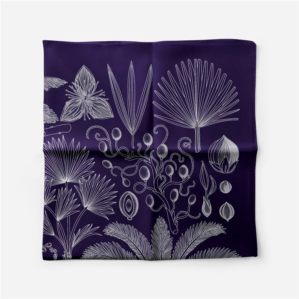 A deep purple silk square scarf featuring a white botanical print of various palm leaves and floral elements.
