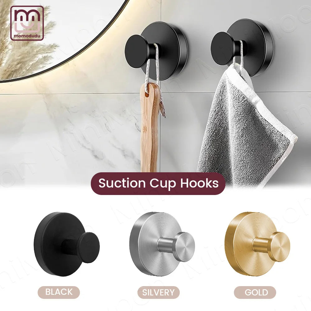Three suction cup towel hooks in black, silvery, and gold finishes shown against a white wall.
