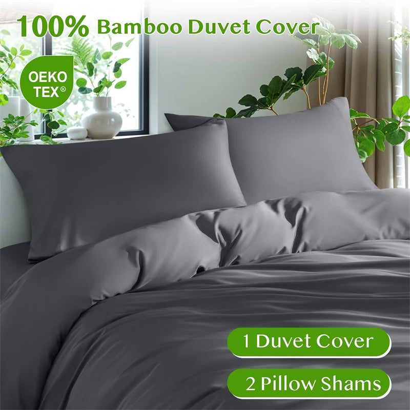 Graue Bambus-Duvetcover-Sets auf einem Bett mit grünen Pflanzen im Hintergrund.