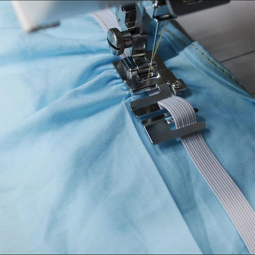 A close-up of an elastic cord and fabric presser foot assembly for a sewing machine, shown on light blue fabric.