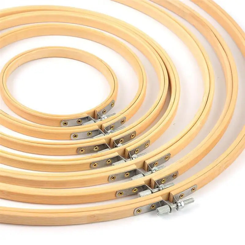 A set of light wood bamboo embroidery hoops with adjustable metal screws.