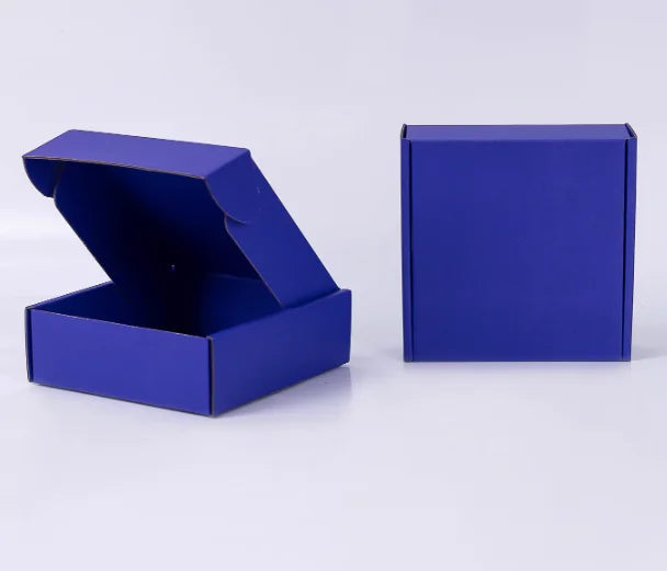 Eine königsblaue Wellpappkarton ist geöffnet und eine geschlossene Box daneben zu sehen.