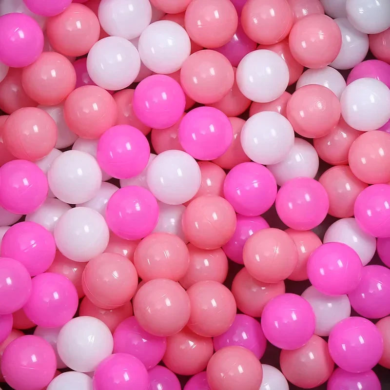 A close-up view of a large pack of colorful plastic ball pit balls in pink and white shades.