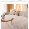 A beige one-piece blanket with a fishbone pattern draped over a light-colored sofa.