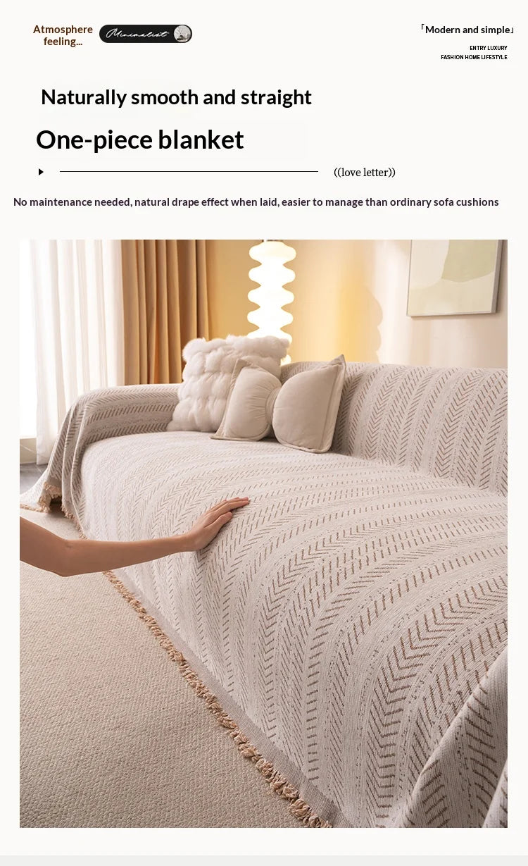 A beige one-piece blanket with a fishbone pattern draped over a light-colored sofa.