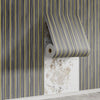 Vertical striped wallpaper featuring gray and yellow lines on a wall surface.