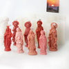 A collection of pink and reddish-orange 3D silicone molds depicting religious figures for candle and resin crafting.