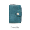 A teal leather short wallet with a silver zipper closure and a round metal button detail.
