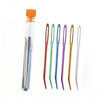 A collection of bent tip tapestry needles in various colors including orange, green, purple, and gold.