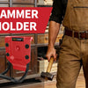 A close-up of a red hammer holder attached to a belt, shown next to a man wearing brown overalls and holding a wooden hammer.