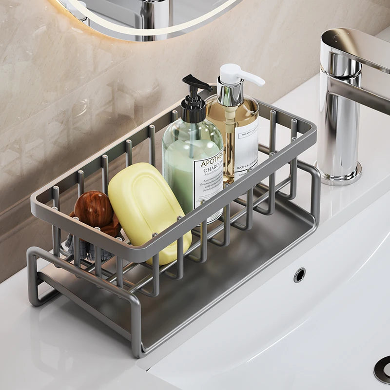 Stainless steel sink organizer rack holding various liquid soap bottles and a yellow dispenser