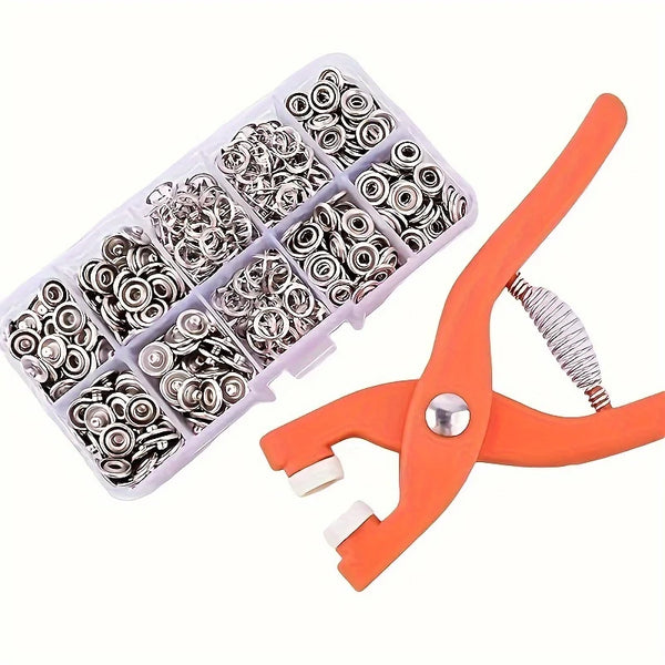 A plastic tray of silver snap buttons and an orange manual press pliers for DIY sewing.
