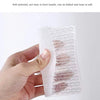Une main tient un ensemble de tampons à vaisselle en silicone et de brosses à crevasses, montrant sa flexibilité.
