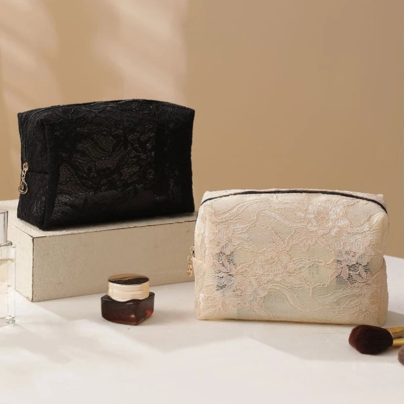 A black lace mesh makeup bag is displayed next to a cream-colored lace mesh makeup bag on a white surface.