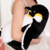A black and white penguin plush toy is held by a person, showing its soft texture and design.