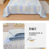 Light blue quilted bedspread with a white geometric pattern and floral accents