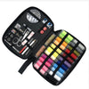 A black portable sewing kit containing various tools like scissors needles and thread spools.