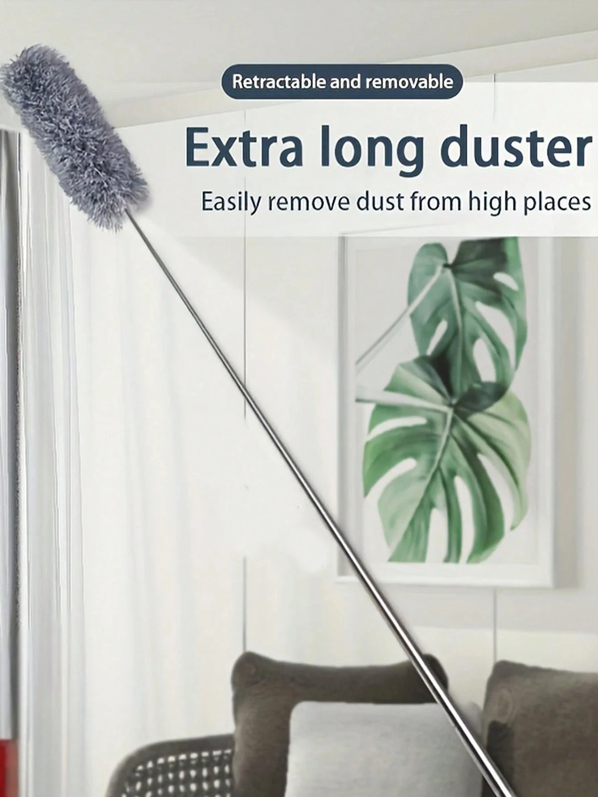 A long, retractable duster with a fuzzy head is shown next to a potted plant in a bright room.
