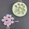 A silicone mold with a flower design, showing the finished pink flowers and the mold itself.
