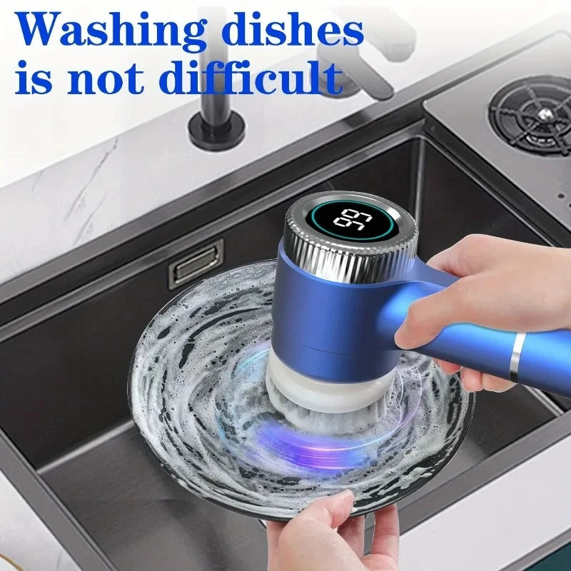 A hand is using a blue cordless electric spin scrubber with a brush head to wash dishes in a kitchen sink.