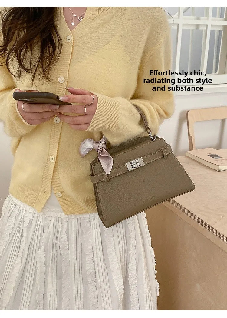 Eine Frau trägt einen gelben Pullover und hält eine elegante taupefarbene PU-Leder-Clutch.