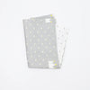 A stack of soft cotton baby pillowcases featuring a light gray background with small yellow cartoon designs.