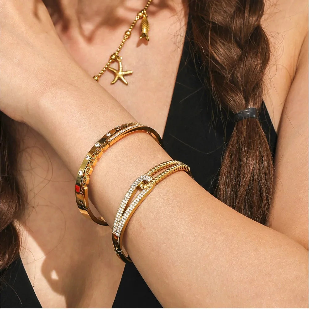 Gros plan sur une femme portant un bracelet à bangle en zircon plaqué or, ouvrable, à son poignet.