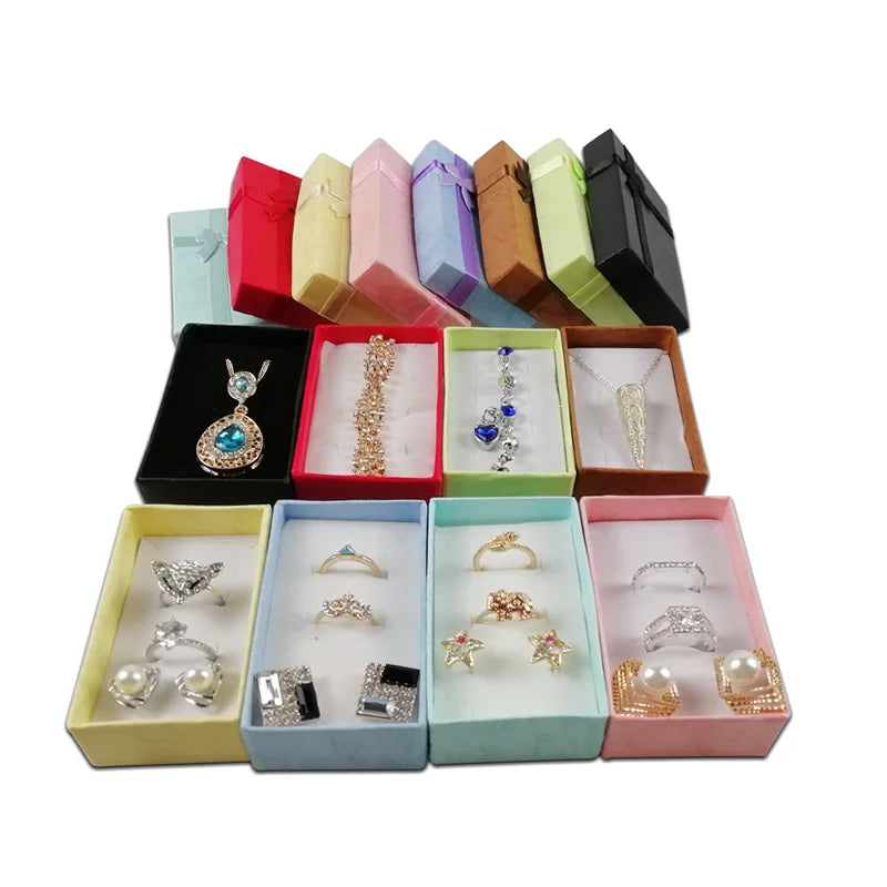 Assorted velvet jewelry gift boxes with cushioned inserts in various pastel and dark colors.