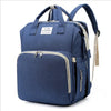 A navy blue backpack diaper bag with a light beige changing mat visible inside.