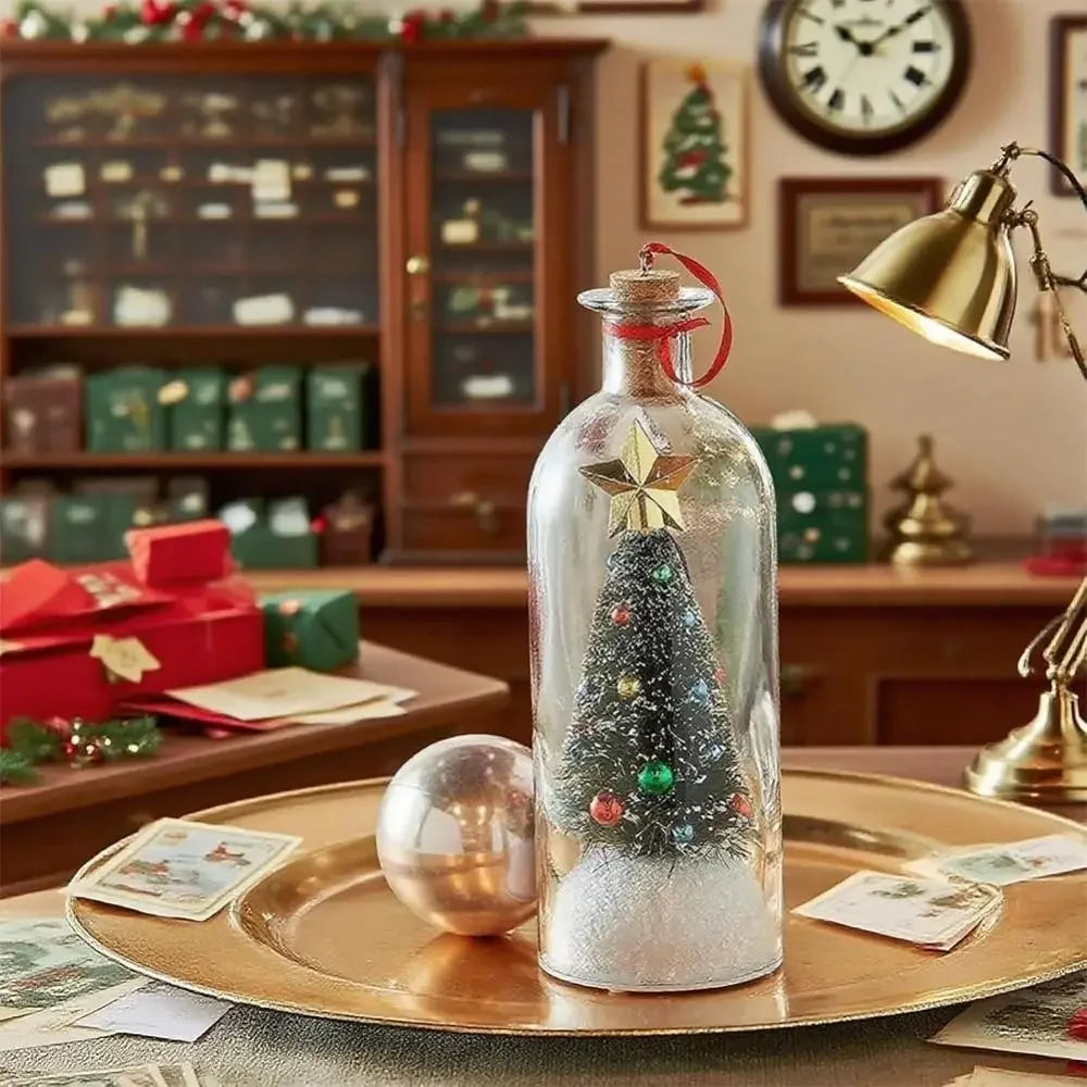 A glass message bottle shaped like a Christmas tree with a star topper sits on a gold plate in a festive holiday setting.