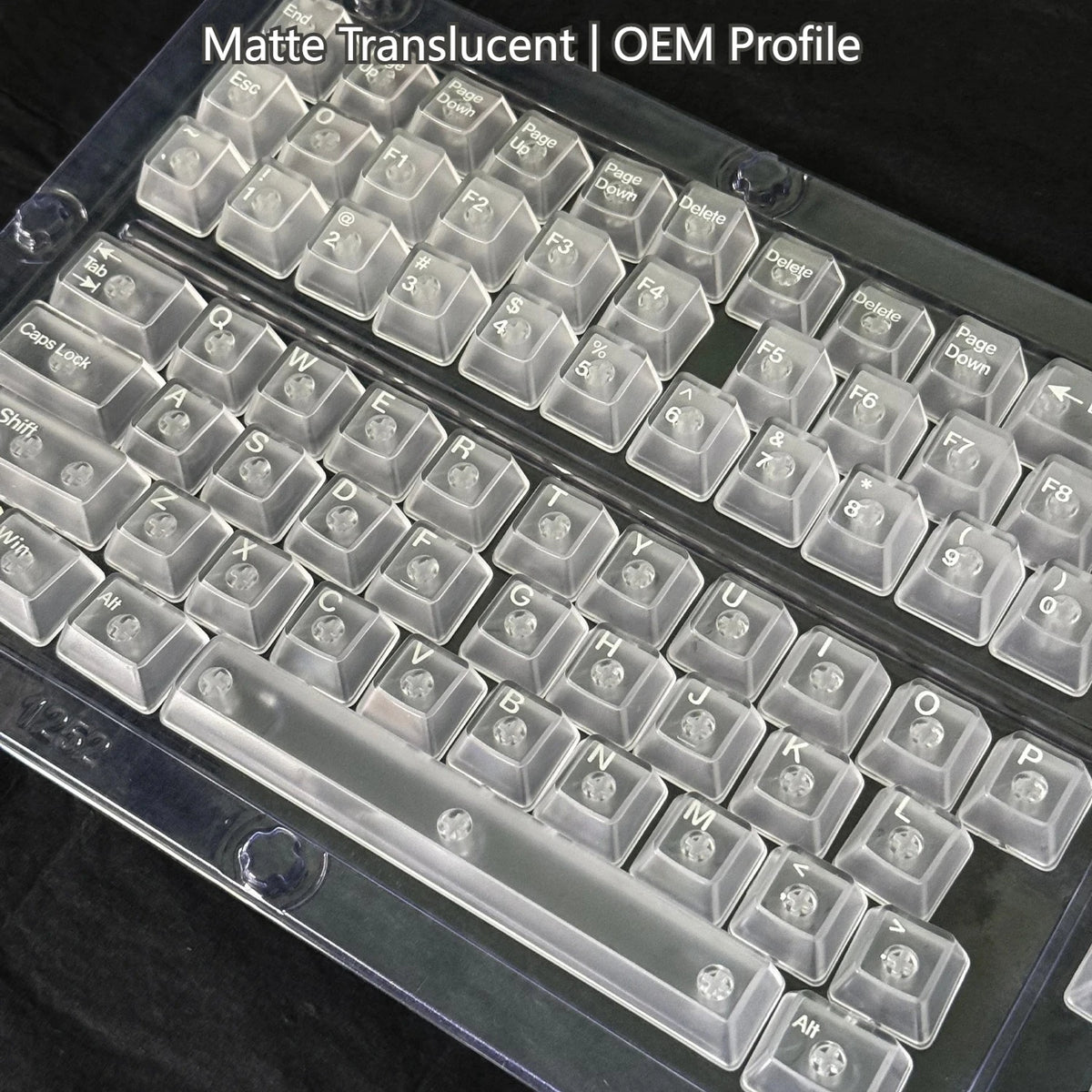 A close-up view of translucent keycaps for a mechanical keyboard, showing various letter and function keys.