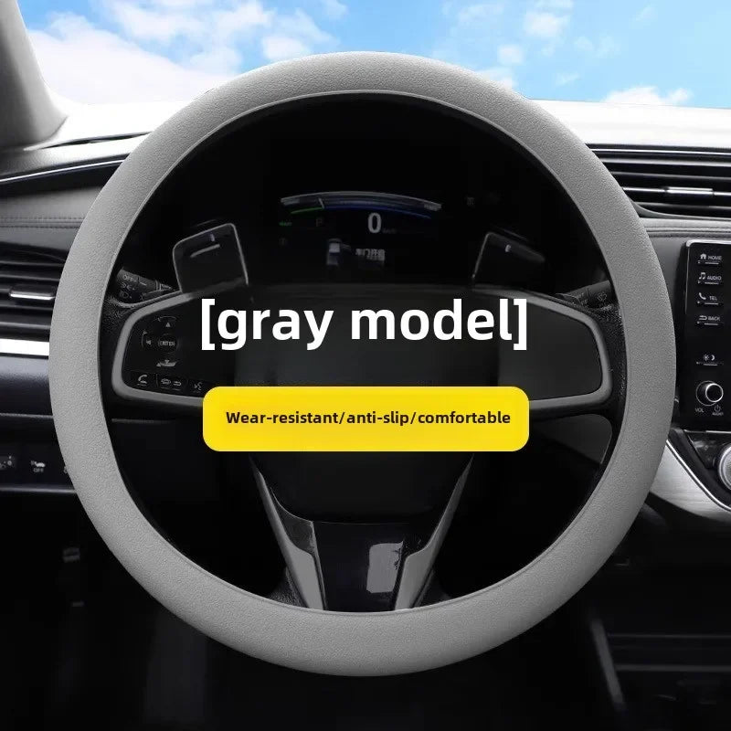 A close-up view of a gray steering wheel with a soft silicone cover, emphasizing wear-resistant and anti-slip features.