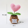 Handmade crochet plant decoration featuring a pink heart flower growing from a brown pot.