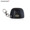 A black garage door remote control with a metal clip attached.