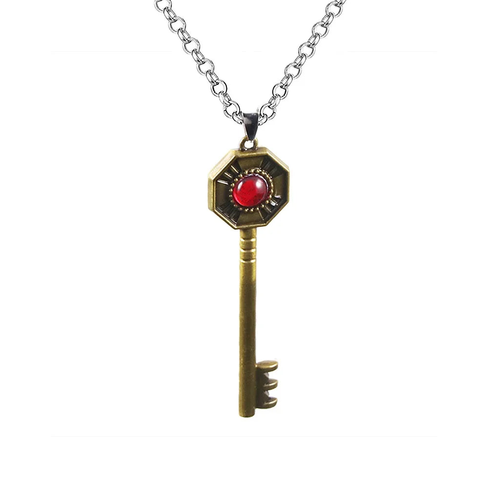 A gold-toned pendant necklace featuring a key design with a red stone and an ornate hexagonal top.