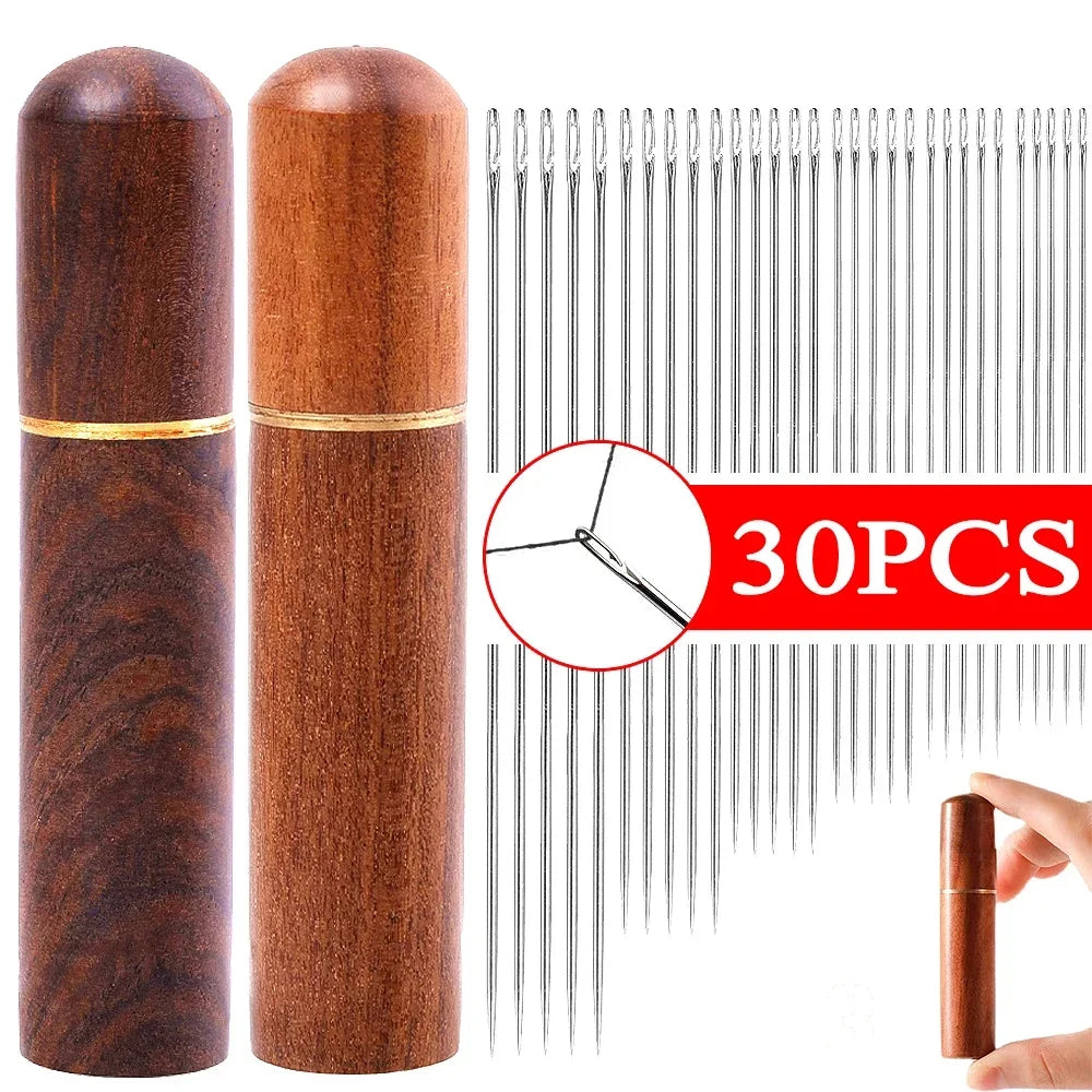 A set of 30 self-threading sewing needles stored in a wooden cylinder with a gold band.