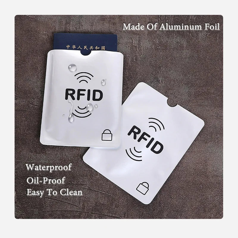 A set of aluminum foil RFID blocking card sleeves, including a clear plastic sleeve and a white card sleeve.