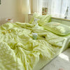 A bright lime green breathable summer seersucker quilt spread out on a bed with white curtains and natural light.