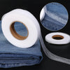 Roll of white double-sided iron-on fabric adhesive tape with a blue denim fabric swatch.
